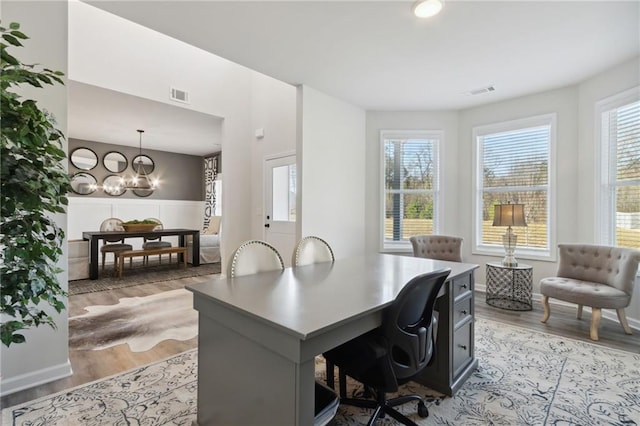 office area featuring a notable chandelier, visible vents, and light wood-style floors