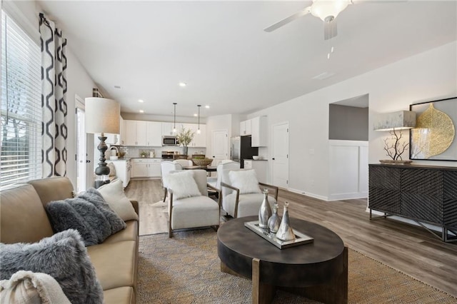 living area with baseboards, recessed lighting, ceiling fan, and wood finished floors