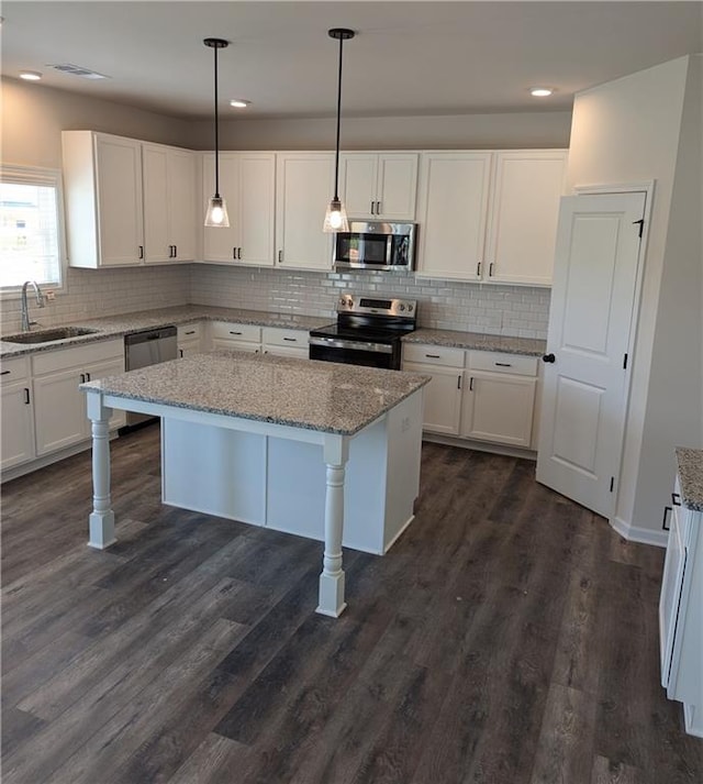 kitchen featuring a sink, appliances with stainless steel finishes, white cabinets, and a kitchen breakfast bar