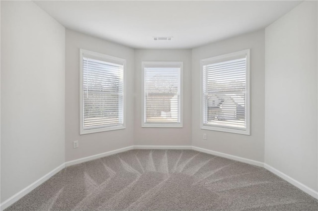 carpeted spare room with baseboards and visible vents