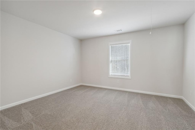 carpeted empty room with baseboards and visible vents