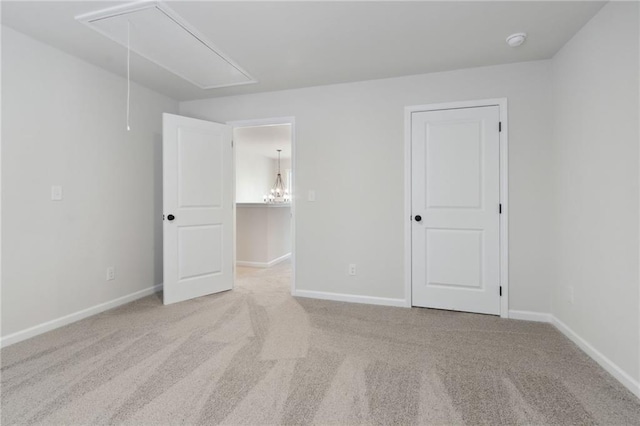 unfurnished bedroom featuring carpet floors, baseboards, and attic access
