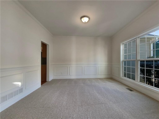 carpeted spare room featuring crown molding