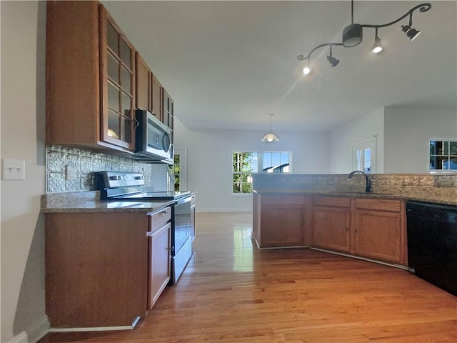 kitchen with backsplash, light hardwood / wood-style flooring, sink, stainless steel appliances, and hanging light fixtures