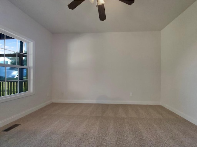 carpeted spare room with ceiling fan