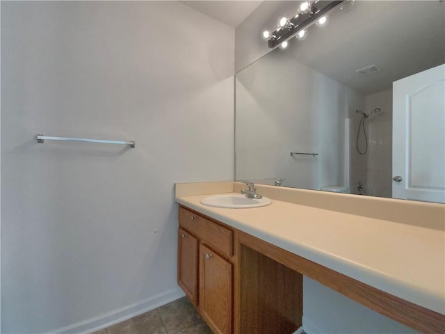 bathroom featuring tile patterned flooring, a shower, and vanity