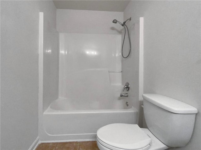 bathroom with bathtub / shower combination, toilet, and tile patterned flooring