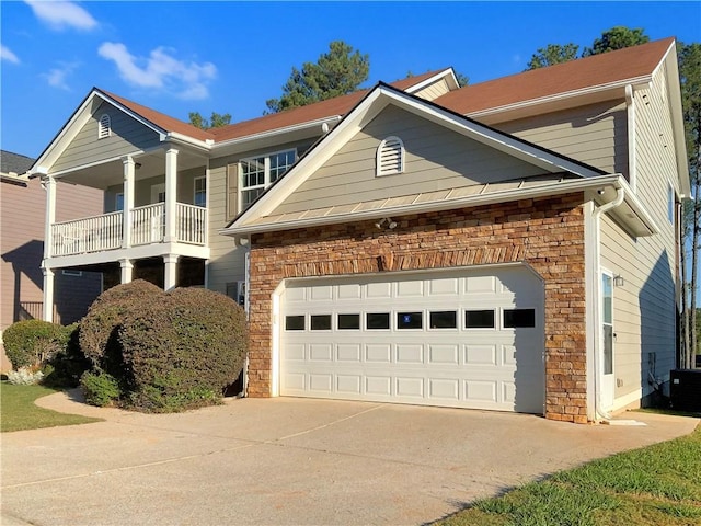 view of front of home featuring central air condition unit, a balcony, and a garage