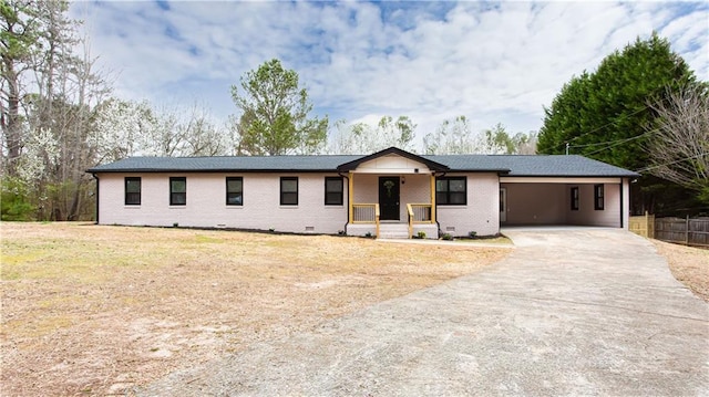 ranch-style house with brick siding, an attached carport, concrete driveway, covered porch, and crawl space