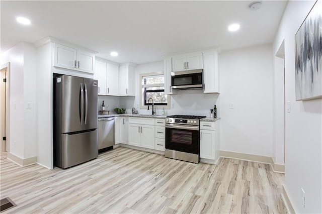 kitchen with stainless steel appliances, visible vents, and white cabinetry