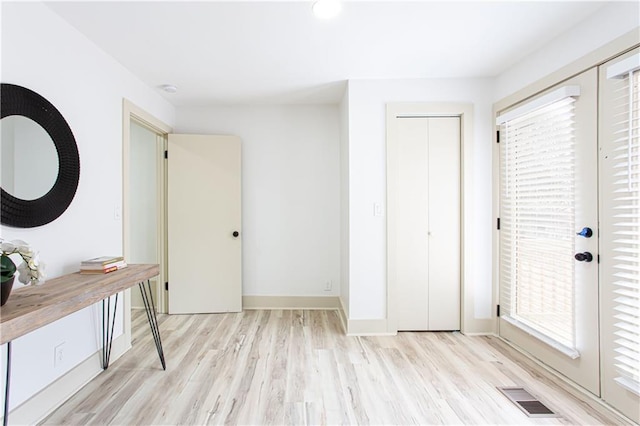 unfurnished bedroom featuring multiple windows, light wood-style floors, and visible vents