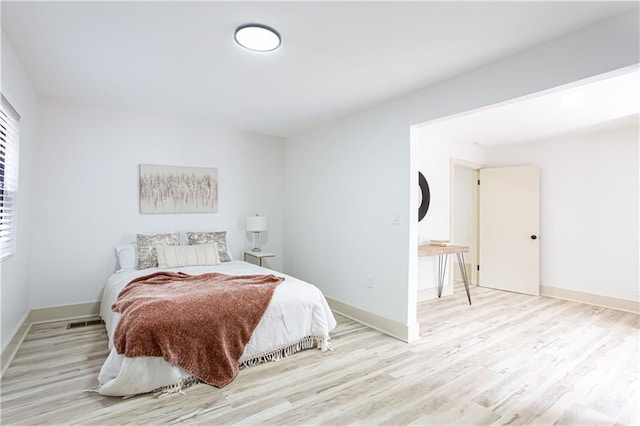 bedroom with light wood-type flooring and baseboards