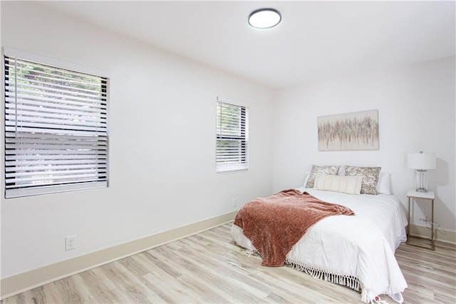 bedroom with baseboards and wood finished floors