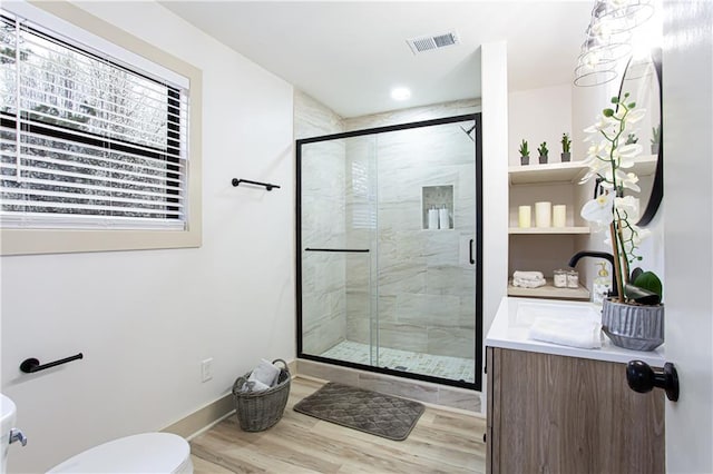 full bath with visible vents, toilet, wood finished floors, a shower stall, and baseboards