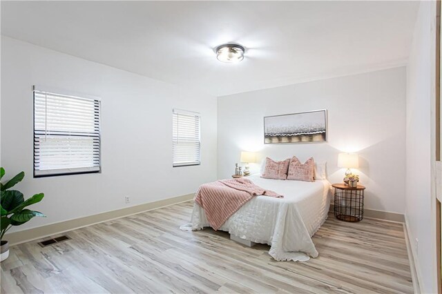 bathroom featuring a shower stall, vanity, baseboards, and wood finished floors