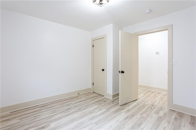 spare room with light wood-style floors and baseboards