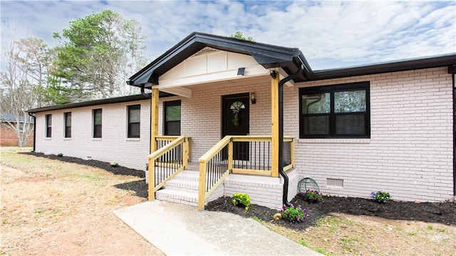 view of front of property featuring brick siding and crawl space