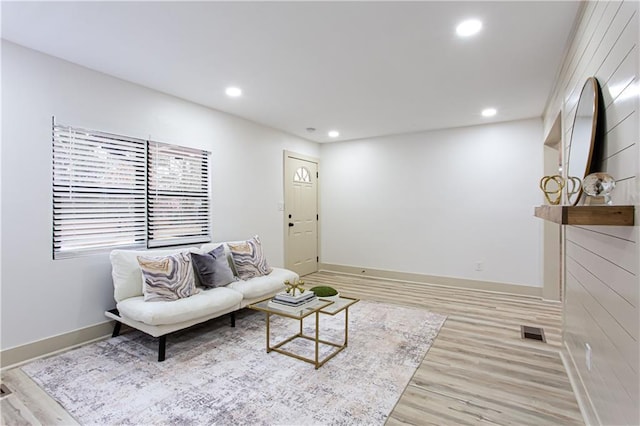 living room with recessed lighting, visible vents, light wood finished floors, and baseboards