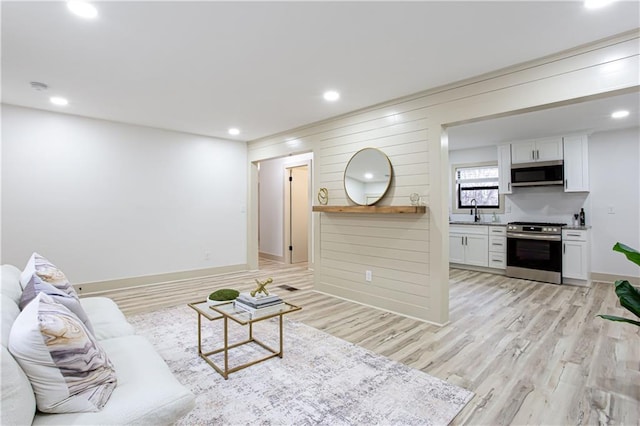 living room with recessed lighting, light wood-type flooring, and baseboards