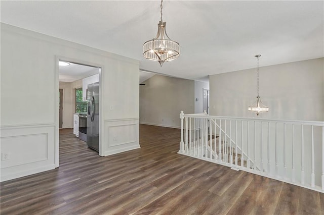 733 Wesley Chapel Rd, Villa Rica, GA 30180 - empty room with a chandelier, dark wood-type flooring, and a decorative wall