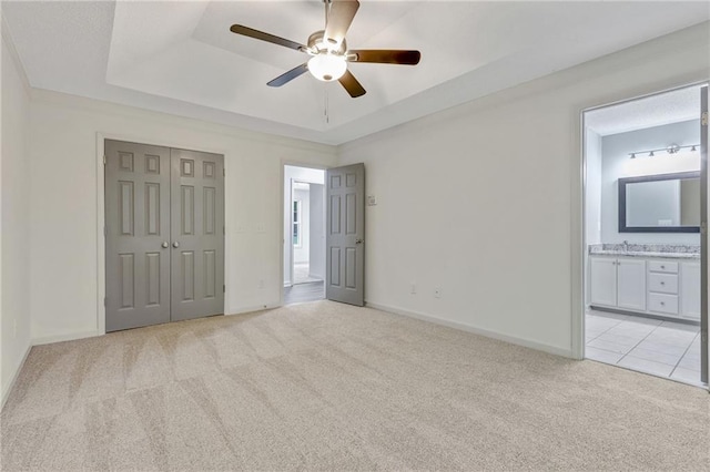 733 Wesley Chapel Rd, Villa Rica, GA 30180 - unfurnished bedroom with light carpet, a tray ceiling, a closet, a ceiling fan, and ensuite bathroom