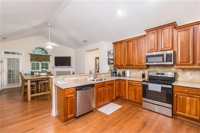 2623 Grapevine Cir Unit 602, Cumming, GA 30041 - kitchen featuring brown cabinetry, tasteful backsplash, a sink, lofted ceiling, and stainless steel appliances