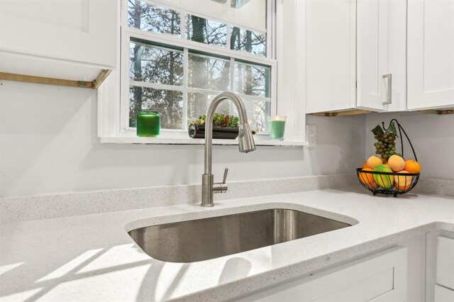 8298 Holly Dr, Jonesboro, GA 30238 - room details with a sink, white cabinets, and light stone countertops