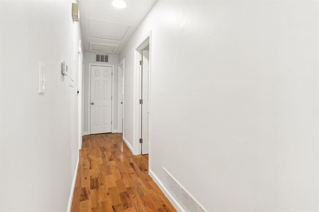 8298 Holly Dr, Jonesboro, GA 30238 - hallway featuring light wood-style floors, visible vents, baseboards, and attic access