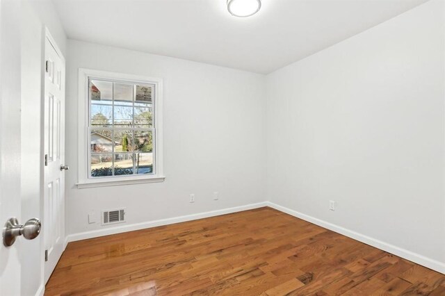 8298 Holly Dr, Jonesboro, GA 30238 - spare room with wood finished floors, baseboards, and visible vents