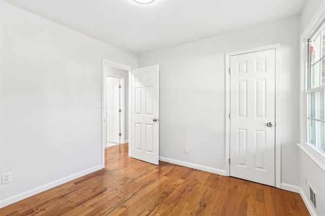 8298 Holly Dr, Jonesboro, GA 30238 - unfurnished bedroom featuring light wood finished floors, visible vents, and baseboards