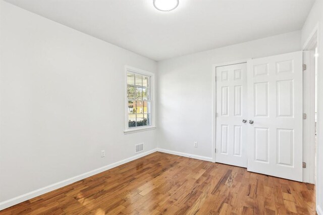 8298 Holly Dr, Jonesboro, GA 30238 - unfurnished bedroom with a closet, visible vents, baseboards, and wood finished floors