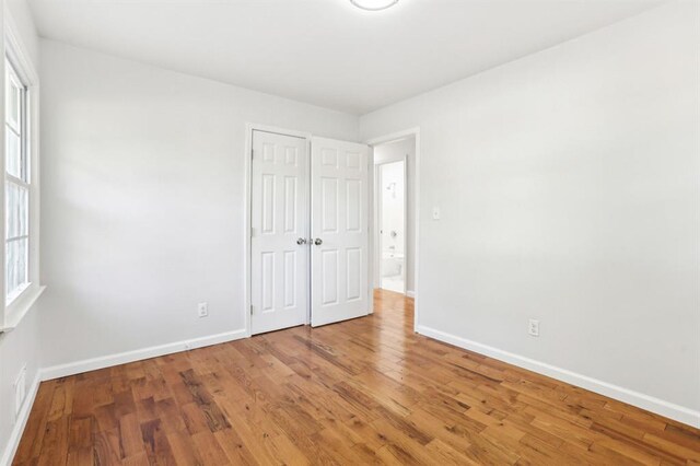 8298 Holly Dr, Jonesboro, GA 30238 - unfurnished bedroom with a closet, baseboards, and wood finished floors