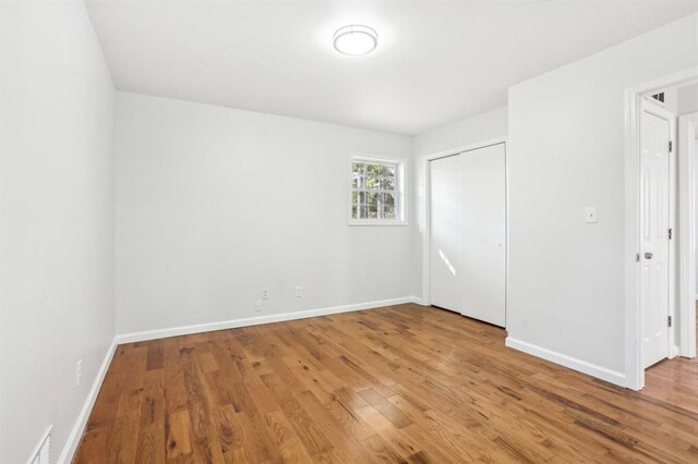 8298 Holly Dr, Jonesboro, GA 30238 - unfurnished bedroom featuring a closet, baseboards, and wood finished floors