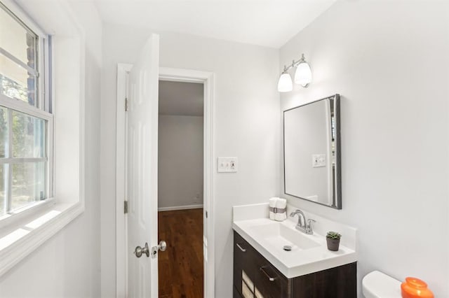 8298 Holly Dr, Jonesboro, GA 30238 - half bathroom with vanity, toilet, and wood finished floors