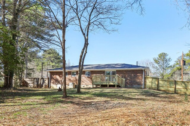 8298 Holly Dr, Jonesboro, GA 30238 - rear view of property with brick siding, fence, a wooden deck, and a yard