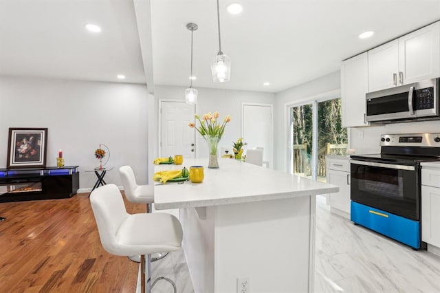8298 Holly Dr, Jonesboro, GA 30238 - kitchen with white cabinets, recessed lighting, light countertops, stainless steel appliances, and a breakfast bar area