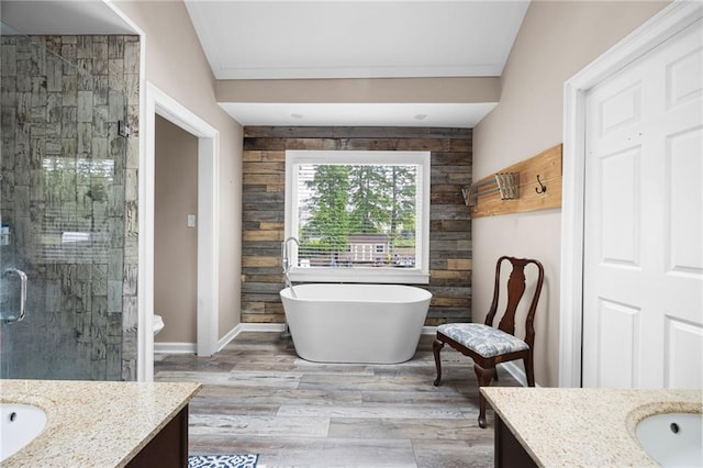full bathroom featuring a freestanding tub, vanity, a shower stall, and wood finished floors