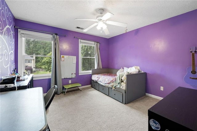 carpeted bedroom with visible vents, a textured ceiling, ceiling fan, and baseboards