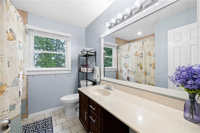 bathroom with a shower with curtain, vanity, tile patterned floors, baseboards, and toilet