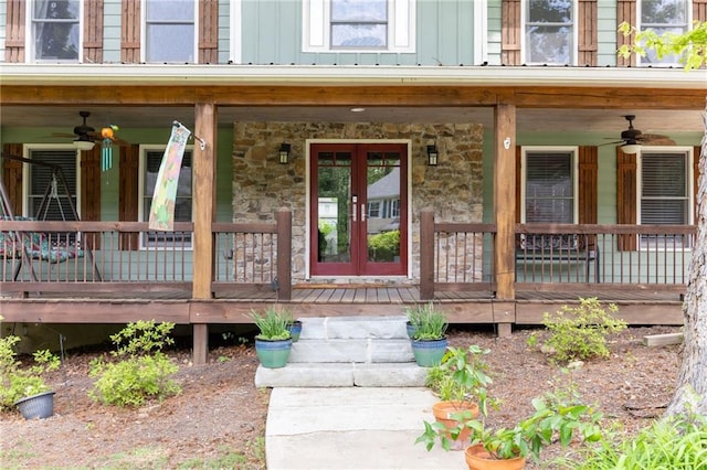 doorway to property with board and batten siding, a ceiling fan, and stone siding