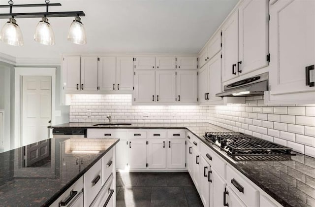 kitchen featuring white cabinets, backsplash, dark tile patterned floors, and dark stone counters