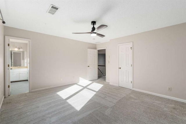 unfurnished bedroom featuring ensuite bath, ceiling fan, a closet, and light colored carpet