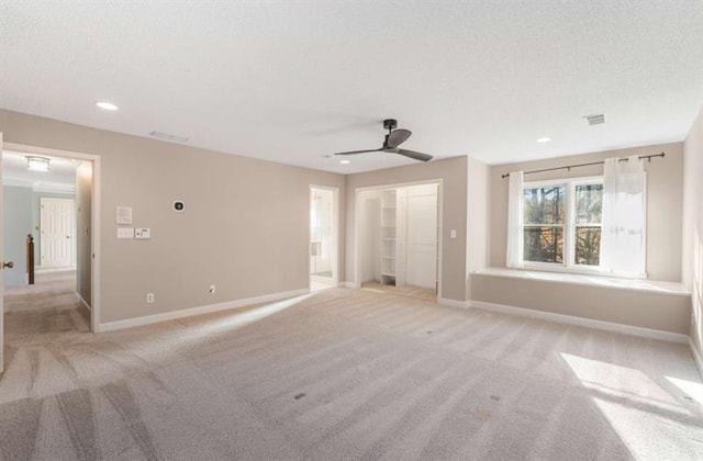 empty room featuring ceiling fan and light colored carpet