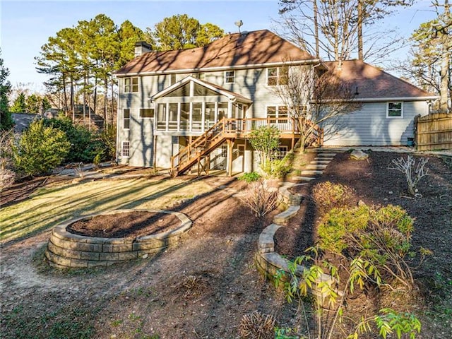 rear view of house featuring a sunroom and a deck