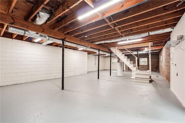 unfinished below grade area featuring stairway and water heater