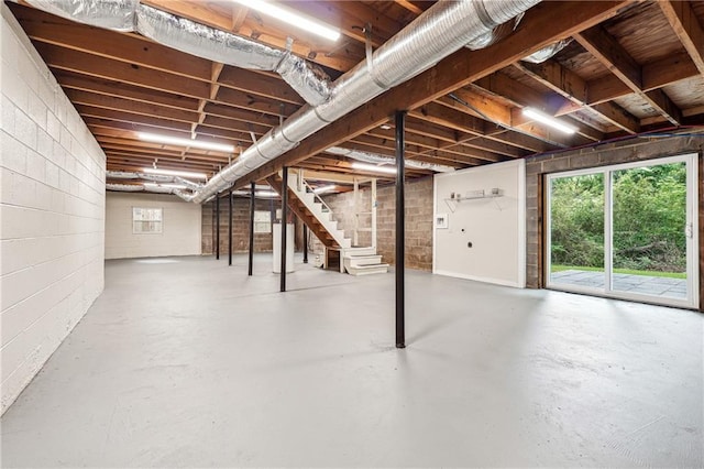 basement featuring stairs and concrete block wall