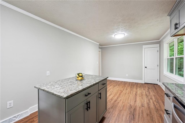 kitchen featuring gray cabinets, a textured ceiling, light wood-type flooring, stainless steel dishwasher, and baseboards