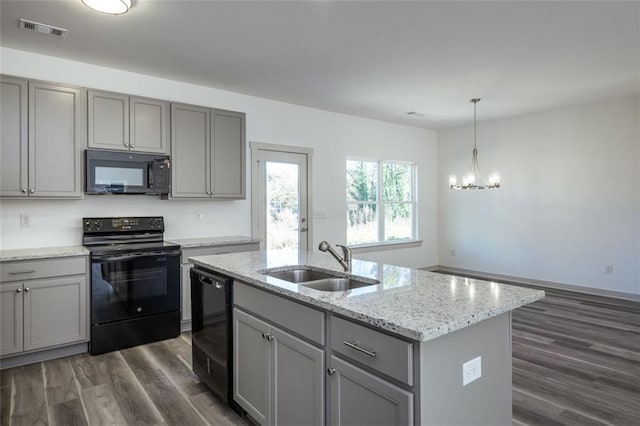 kitchen featuring gray cabinetry, black appliances, a center island with sink, sink, and dark hardwood / wood-style flooring