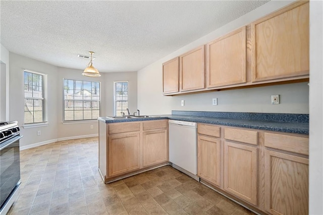 kitchen featuring dark countertops, stove, a peninsula, white dishwasher, and light brown cabinets