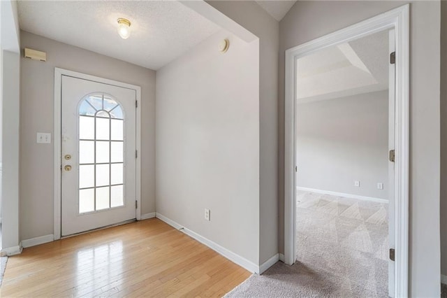 doorway to outside featuring wood finished floors, a wealth of natural light, and baseboards